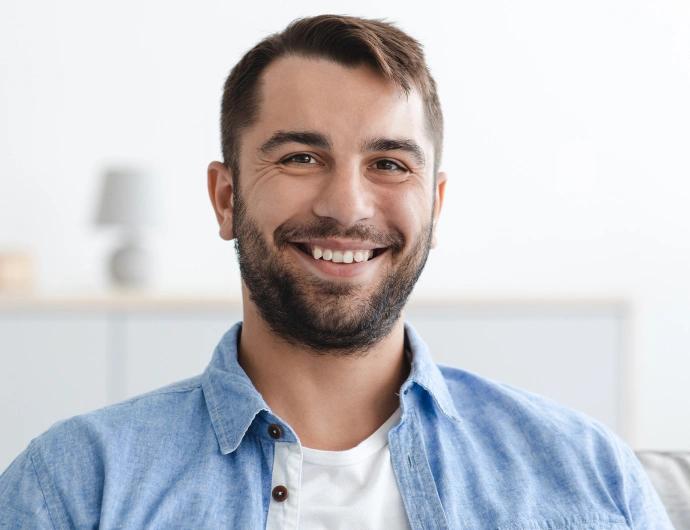 Smiling male dental professional in blue shirt at Brown Road Dental office setting.