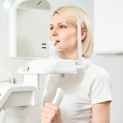 Woman undergoing dental X-ray examination in modern dental office setting.