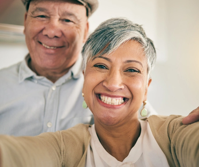 Two smiling dental professionals posing together in a bright clinical office setting.