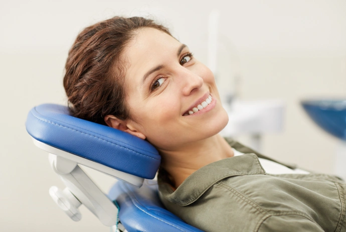 Woman smiling in dental chair with blue headrest during dental appointment at Brown Road Dental.
