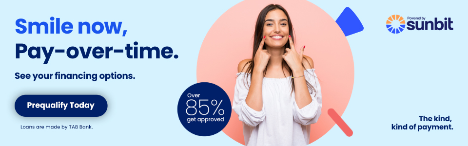 Woman smiling in dental office promoting Sunbit payment plan financing options.