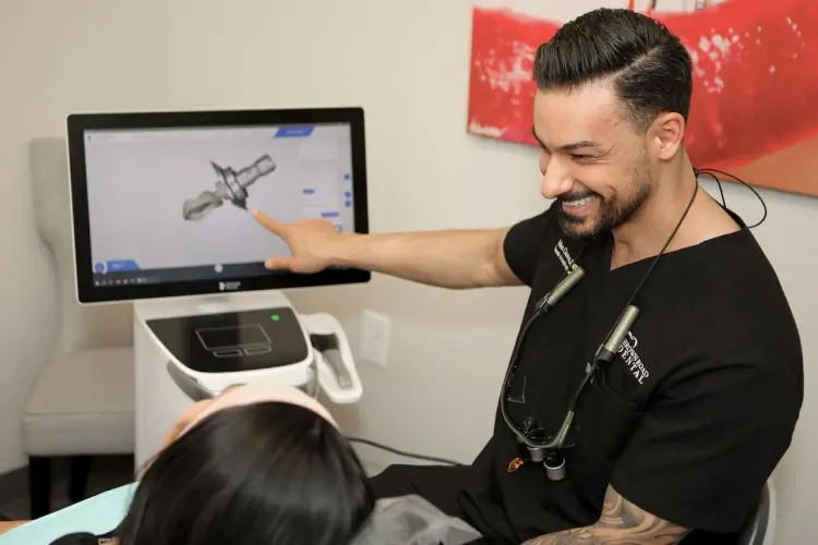 Dentist showing a patient a 3D dental implant model on screen