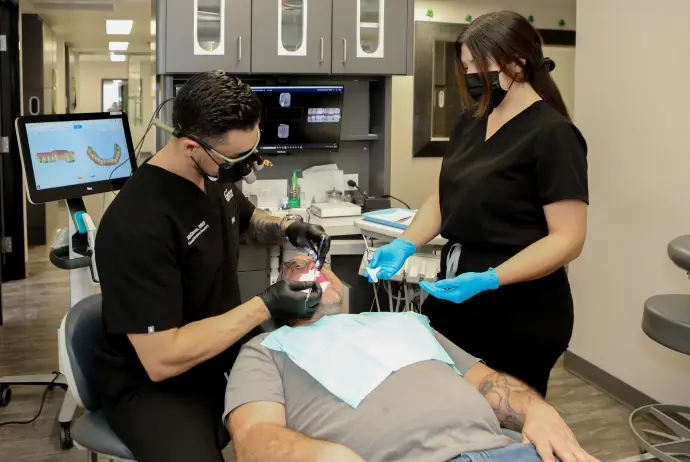 Dentist performing dental restoration treatment on patient in Mesa dental office.