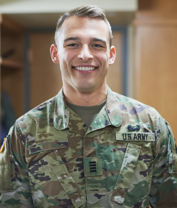 Smiling U.S. Army soldier in camouflage uniform, representing dental assistance for veterans and service members at Brown Road Dental in Mesa, AZ